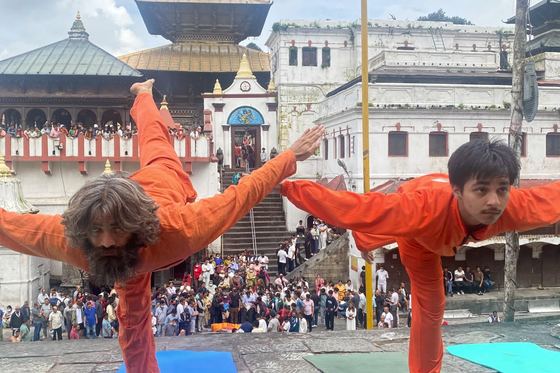 Students and teachers practising yoga together on mats in a courtyard at Pashupatinath
